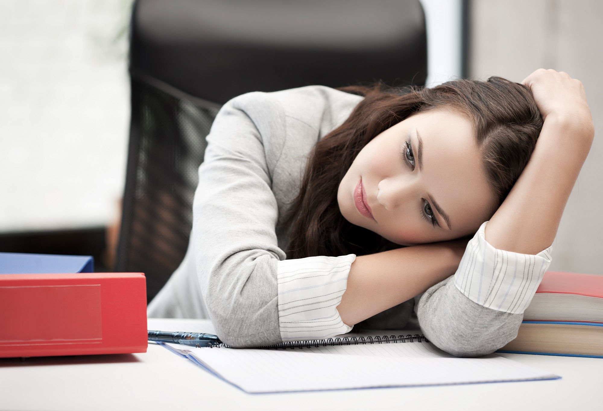 Junge Frau langweilt sich am Arbeitsplatz