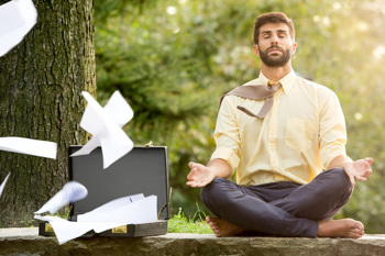 Mann mit Aktentasche macht Yoga