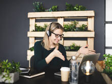 Junge Frau hält Kaffeetasse auf Tisch