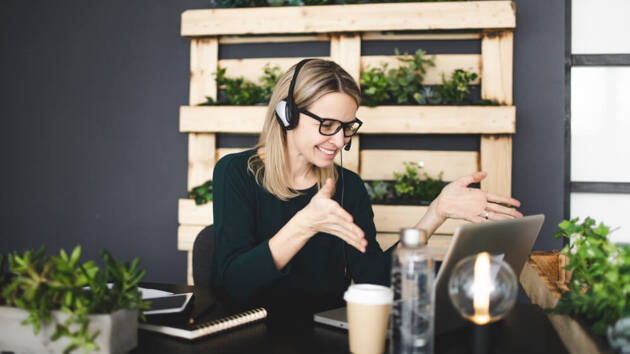 Junge Frau hält Kaffeetasse auf Tisch