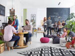 Viele junge, kreativ aussehende Menschen tummeln sich in einem Co-Working-Space.