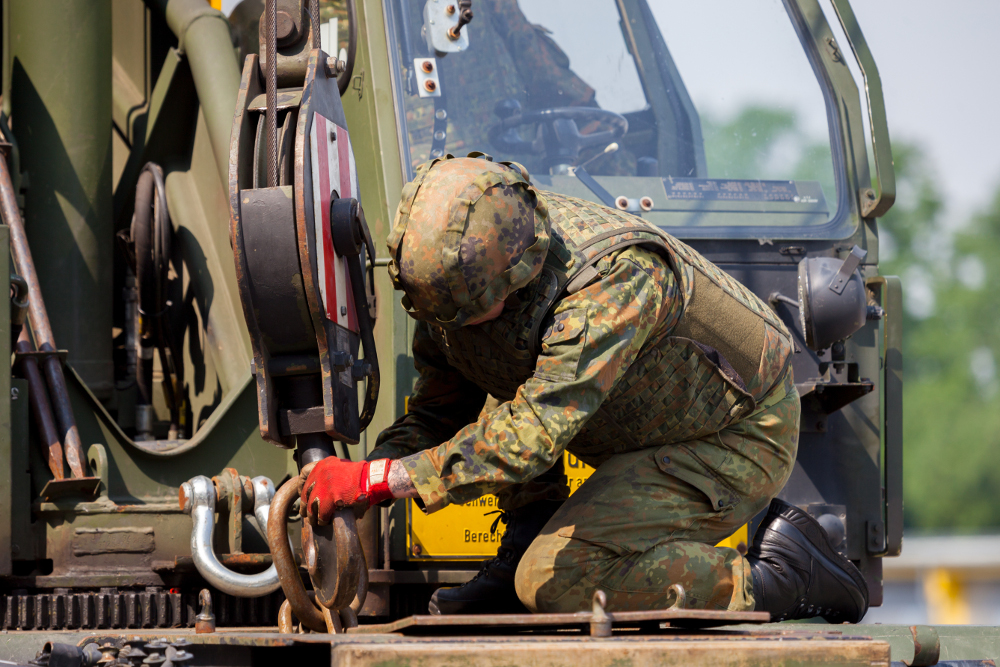 Ein Soldat der Bundeswehr repariert schweres technisches Gerät