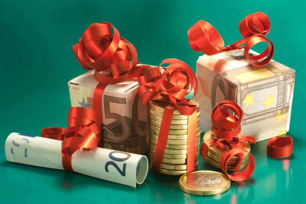 Münzen und Geldscheine verpackt wie kleine Geschenke.