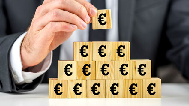Holzklötze mit Euro-Symbolen werden als Pyramide gestapelt